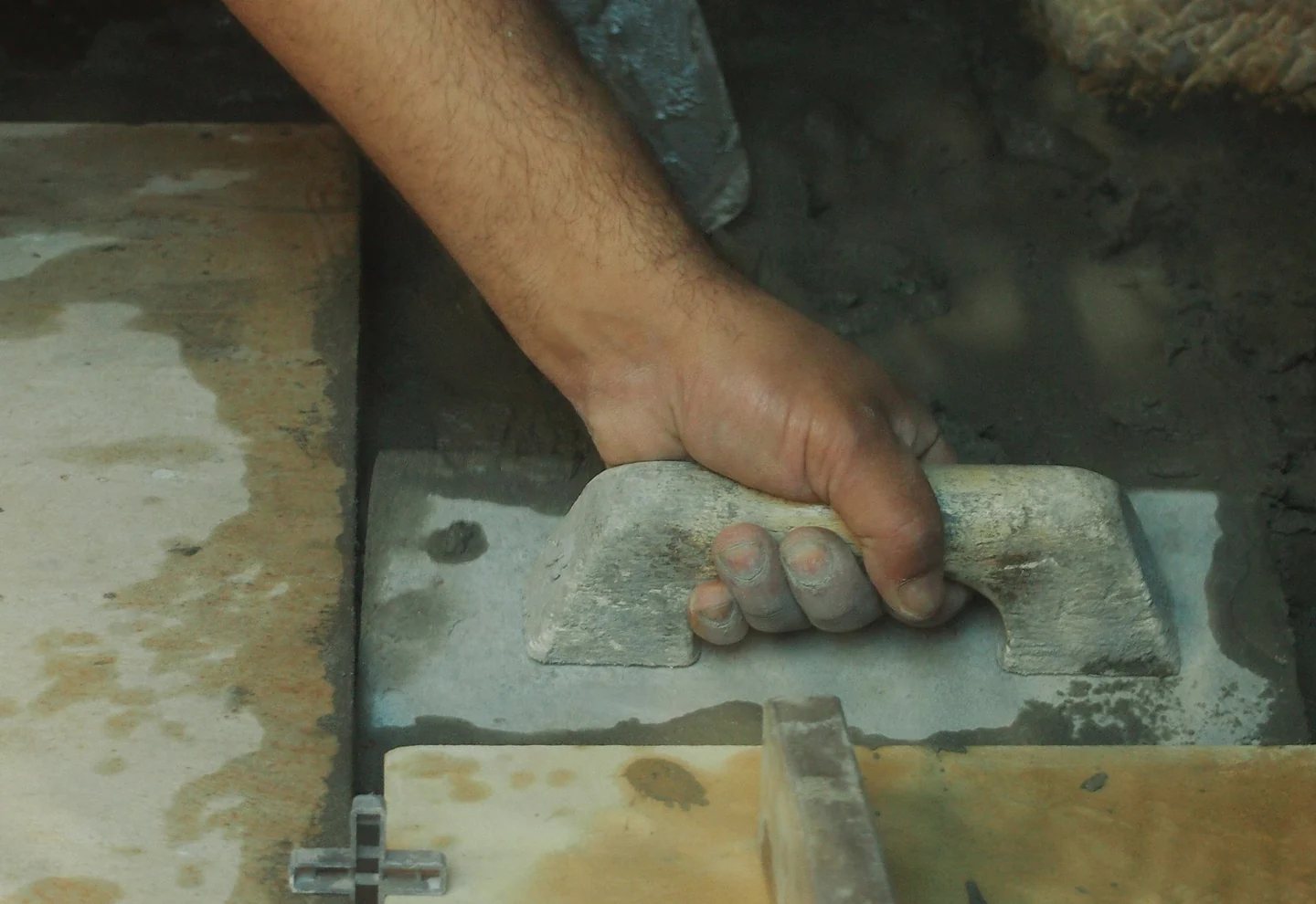 Tile adhesive being applied during ceramic floor installation